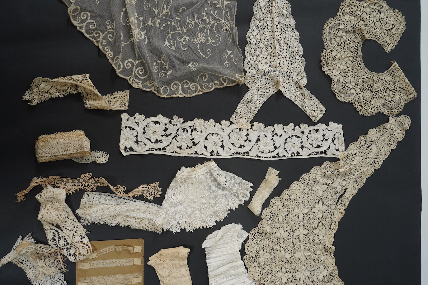 A needle run embroidered net skirt, a similar Bertha, five large silk Maltese bobbin lace collars and trimming, a length of Venetian style lace, mittens etc. Condition - good